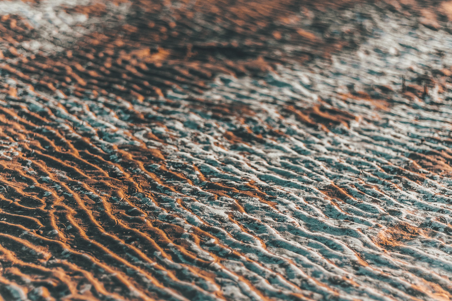 Close-up of rippled ochre and blue-green rock